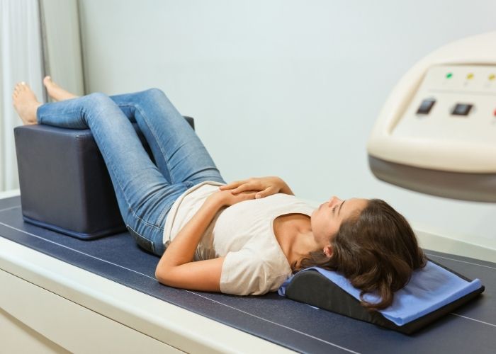 Woman lying on a DEXA scan machine during a bone density scan to assess bone strength and fracture risk